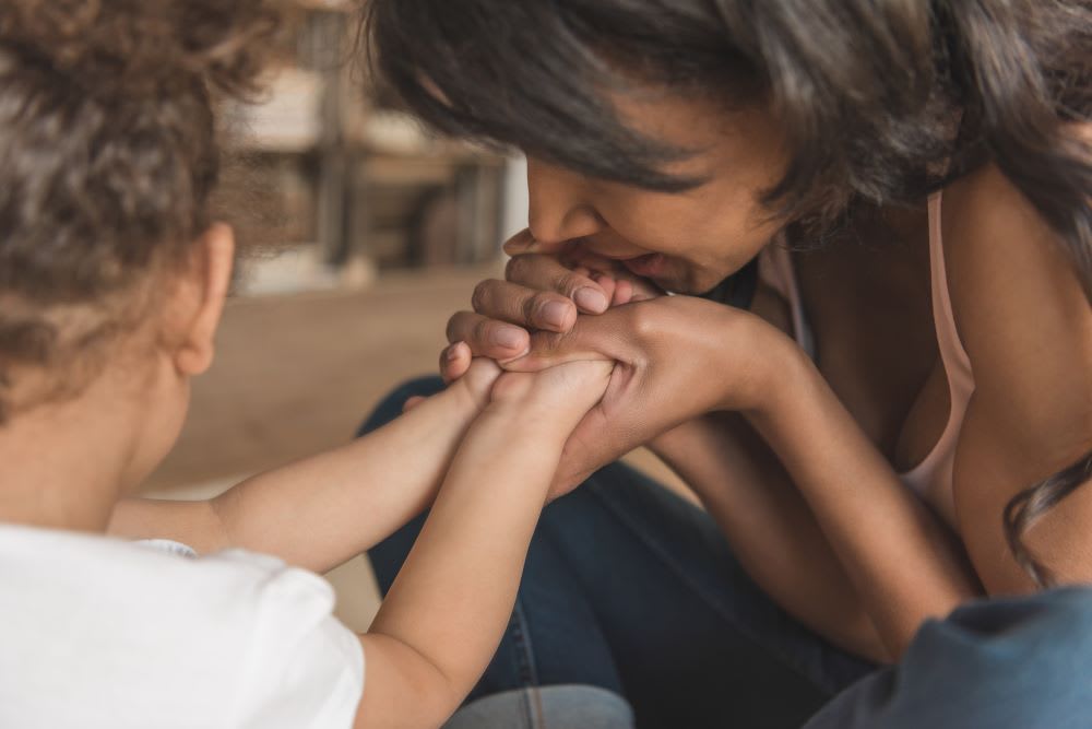 mom kissing toddler hands: divorce advice