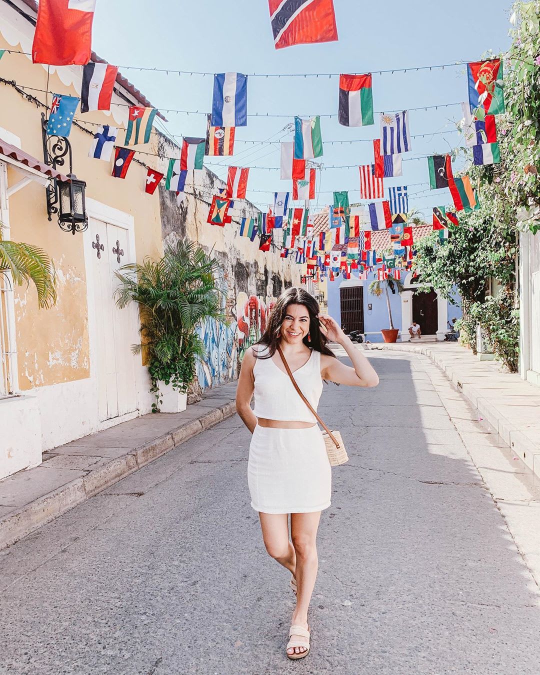 woman walking down a street with flags: travel safety tips