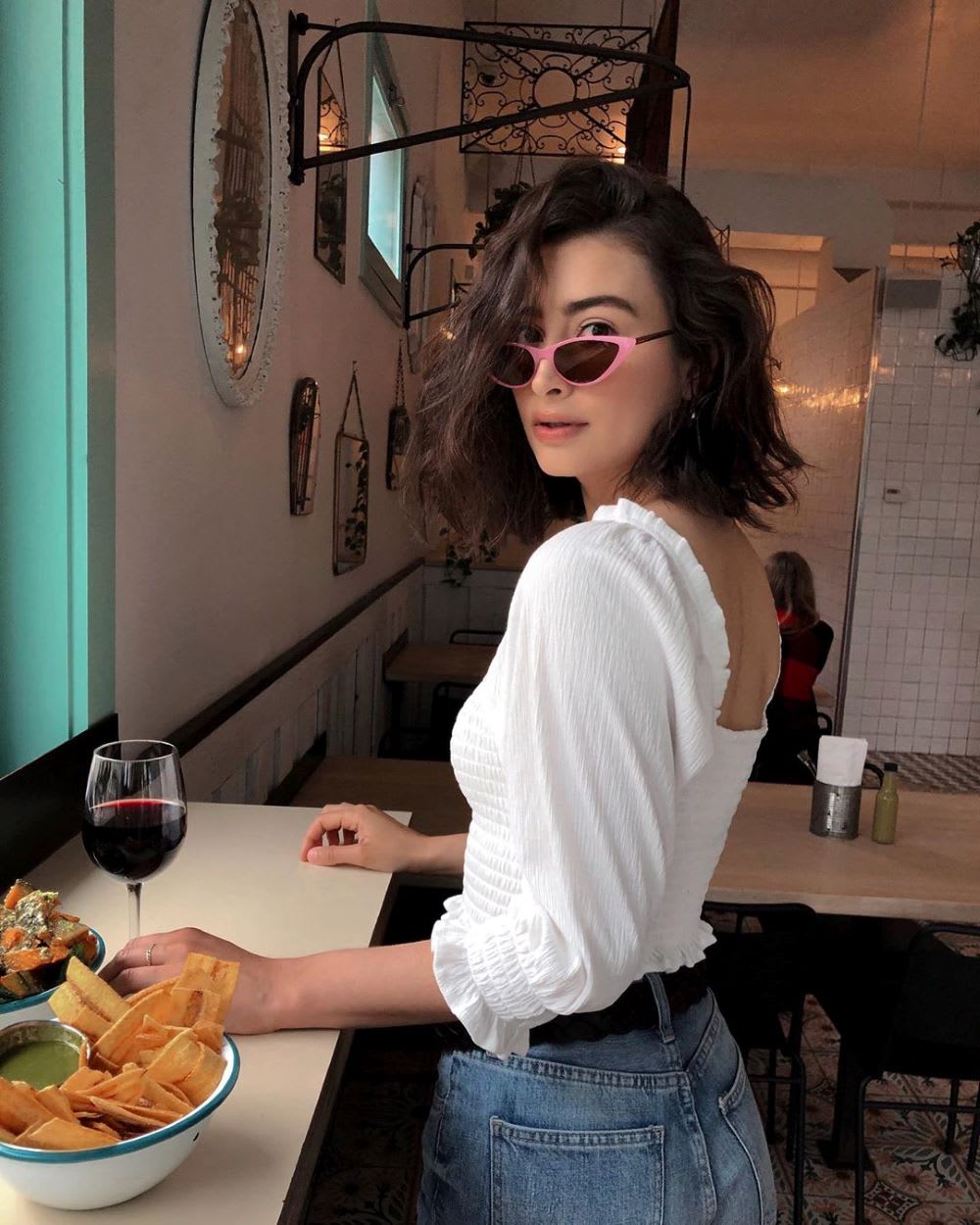 woman in white top and sunglasses shows How to host a wine tasting party on national wine day