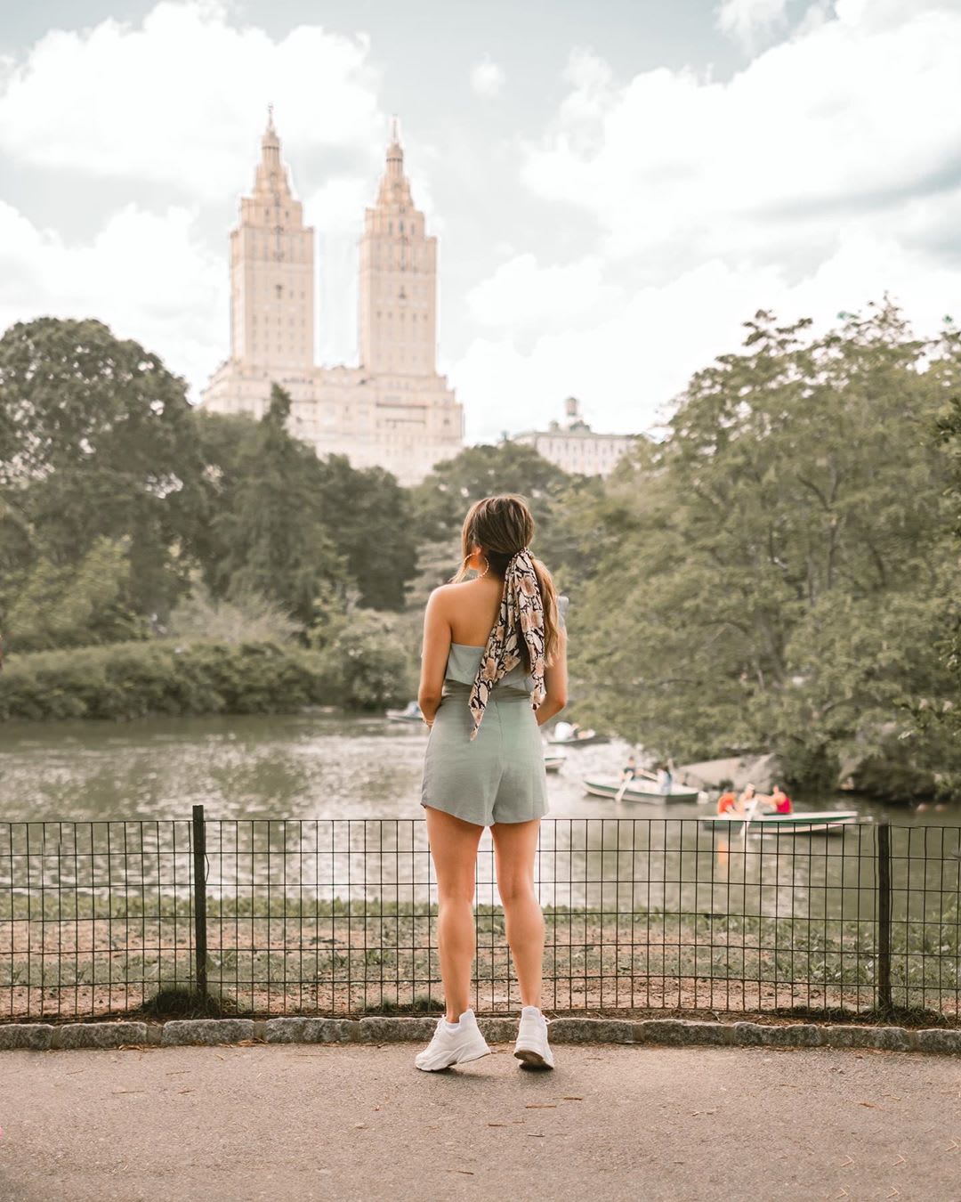 woman in a romper standing in the city park