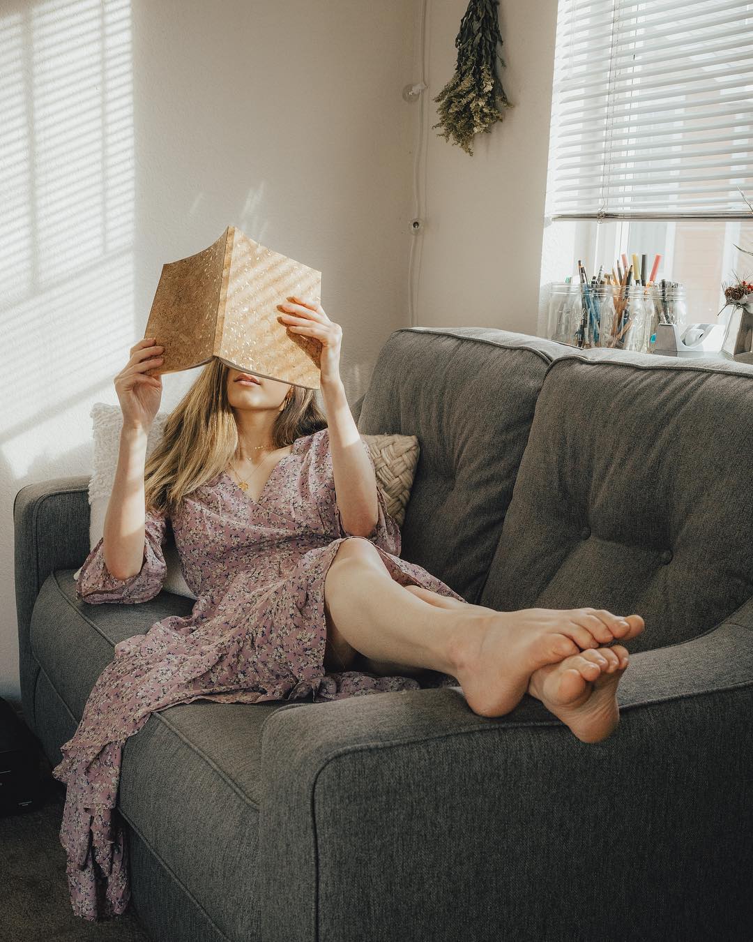 woman reading a book at home on the couch