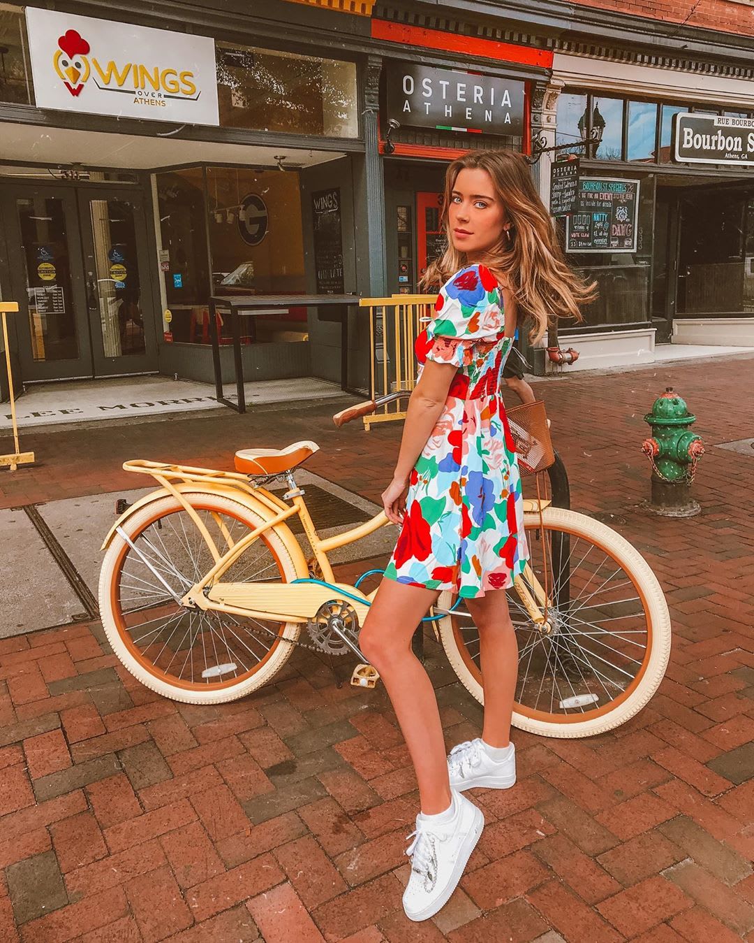 woman in printed dress with a yellow bicycle
