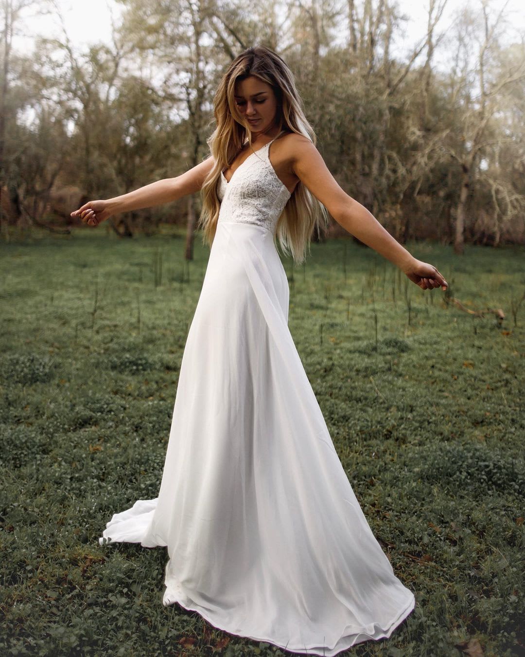 a woman twirling in a white maxi dress for prom or wedding 