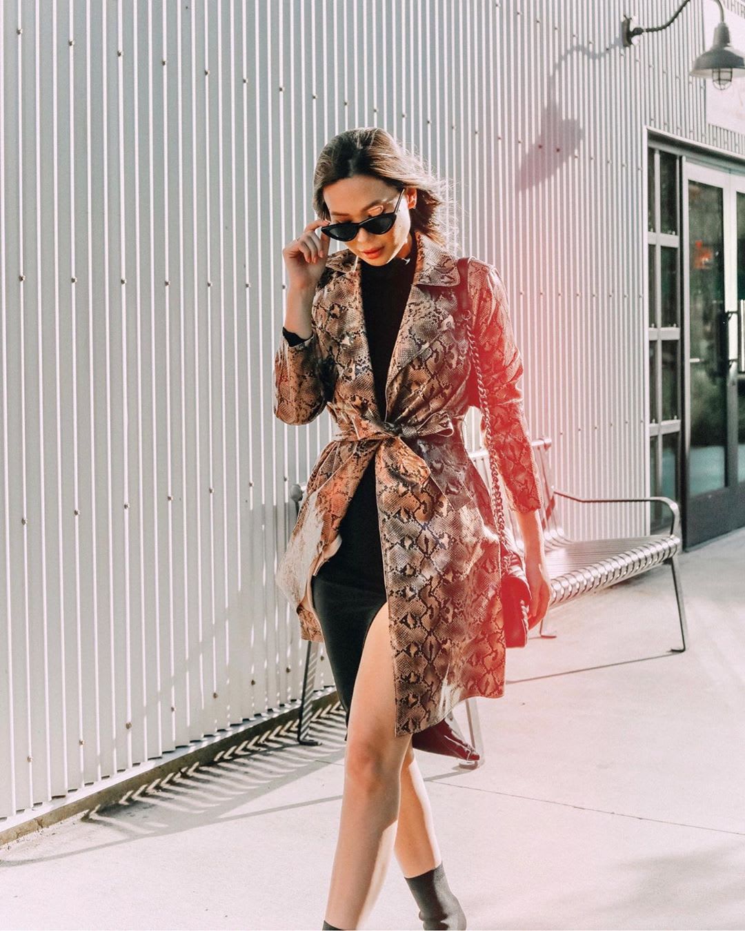 woman walking down city street in snake trench