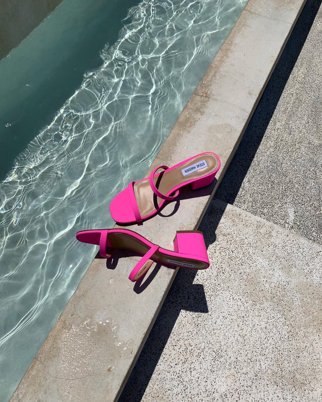 pink heels by a swimming pool for party