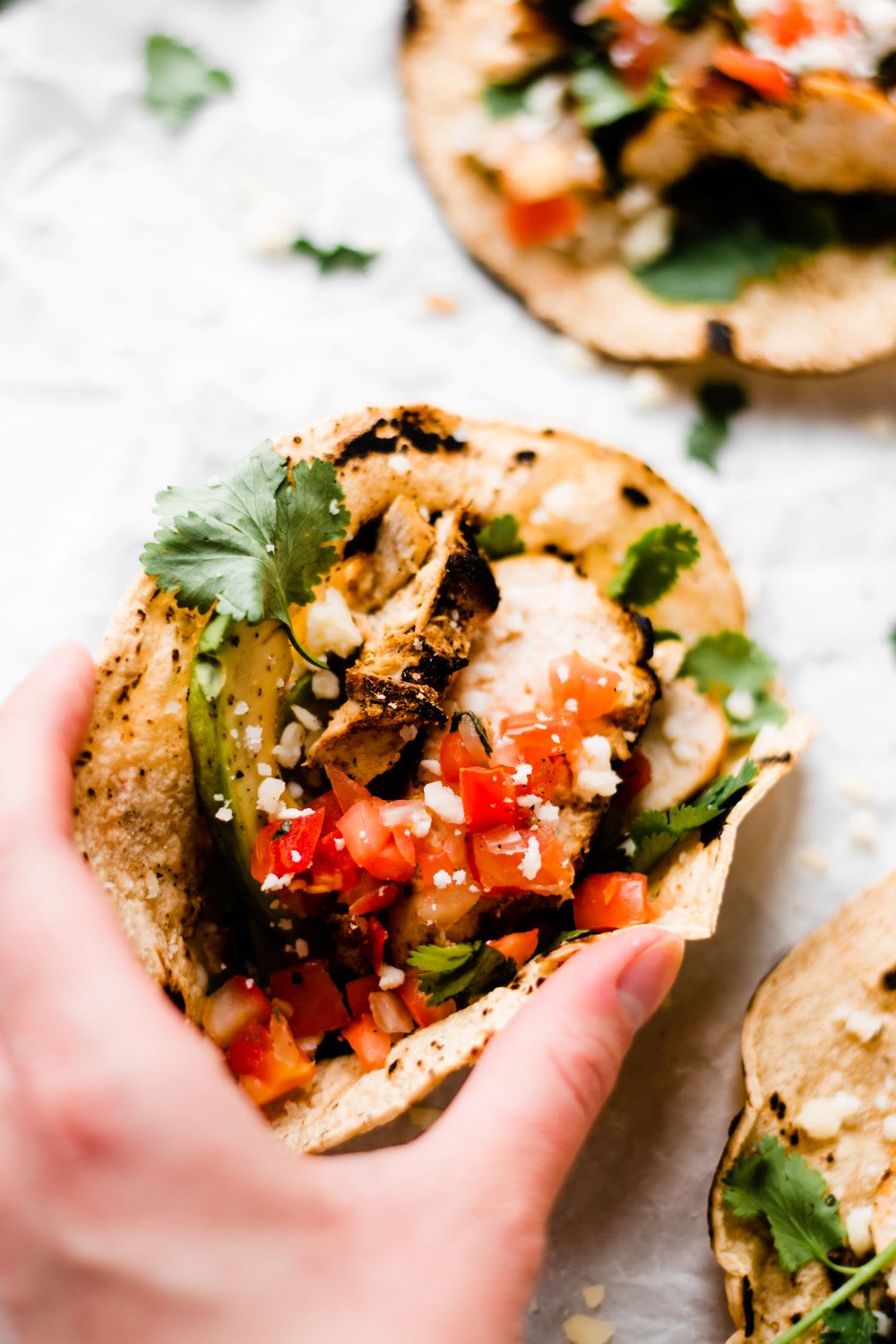 hand holding chicken tacos