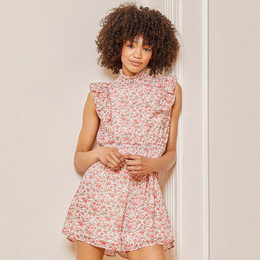 model wearing white floral print ruffled mock neck romper