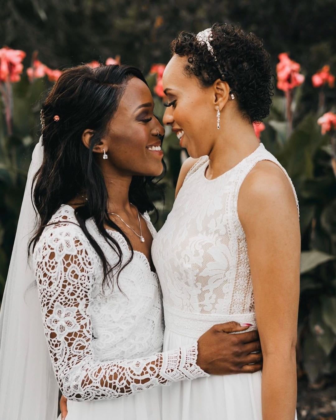 lesbian brides embracing in lace dresses