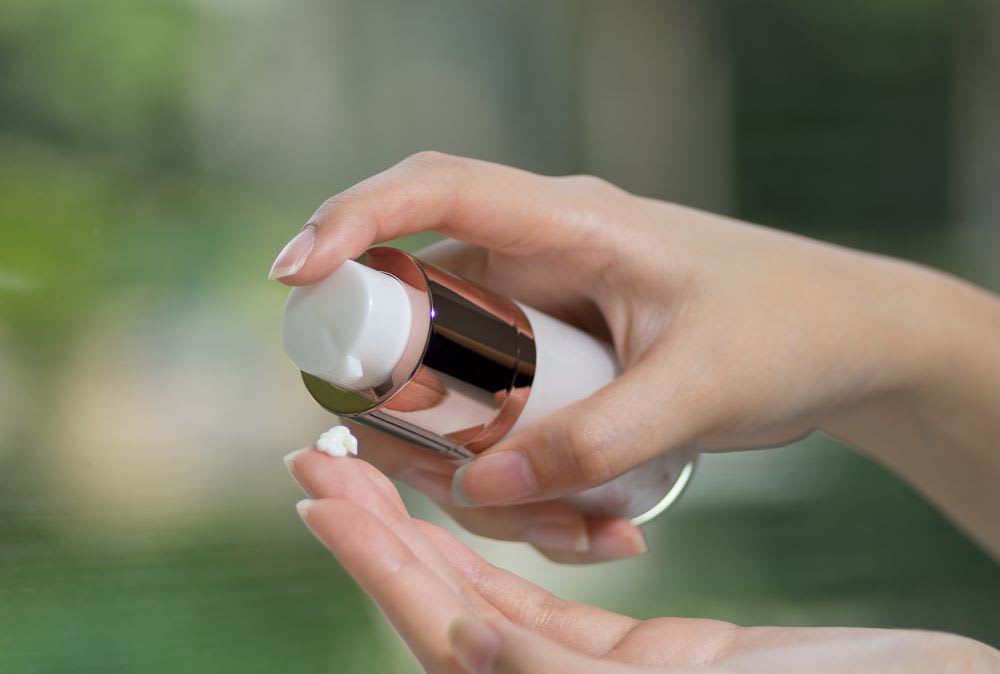 hand putting RE:Erth eye cream on hand for mochi skin