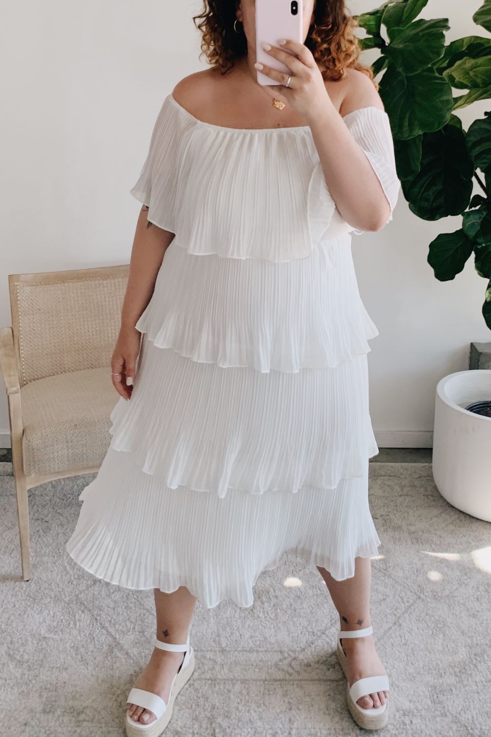 woman in a tiered white dress taking a selfie for virtual wedding