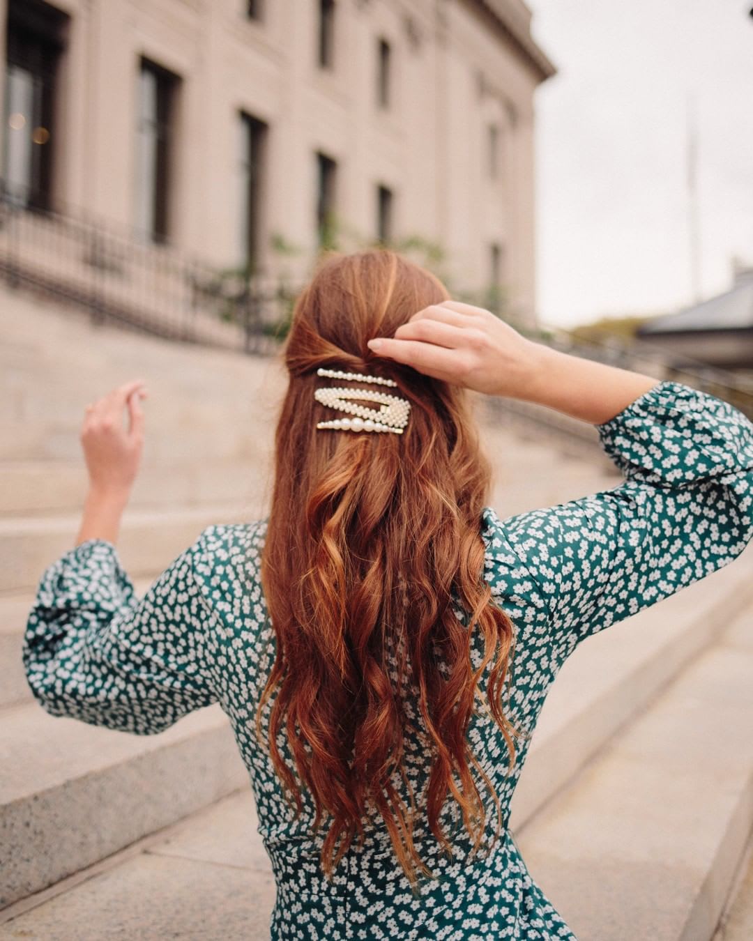 back of woman with red hair wearing pearl hair clips