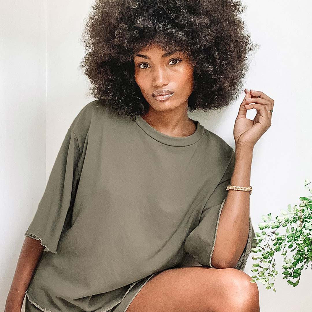 woman in olive green oversized tee and lounge shorts