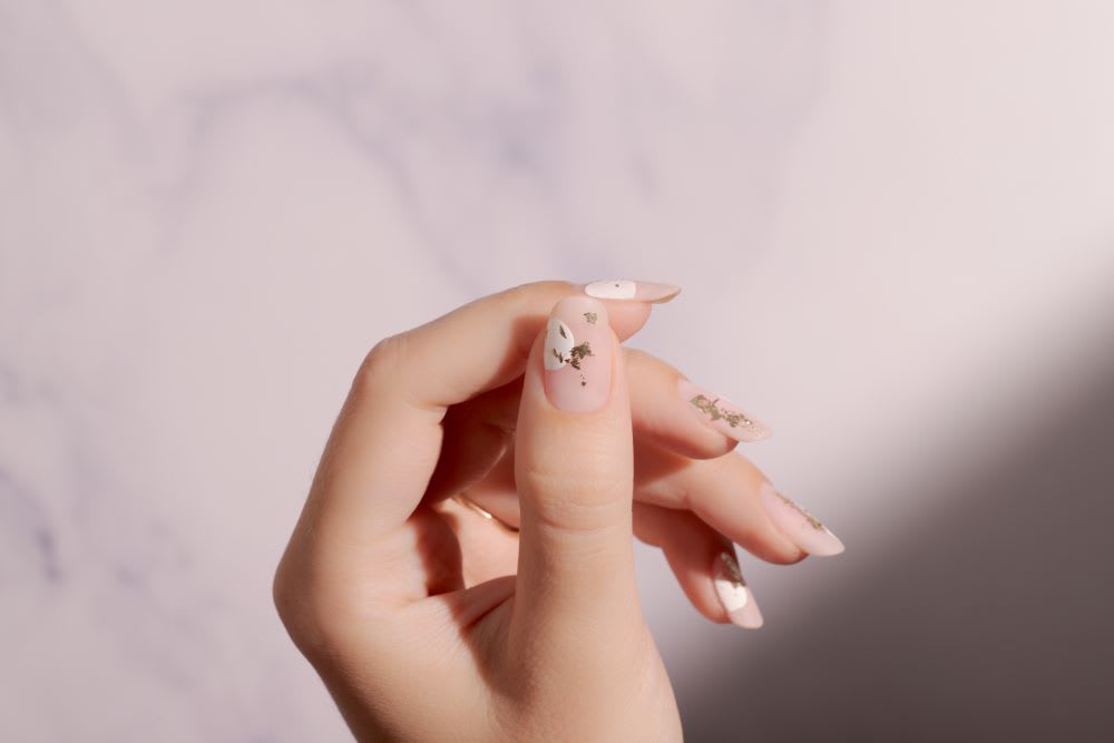 gold foil nail art with white abstract shapes