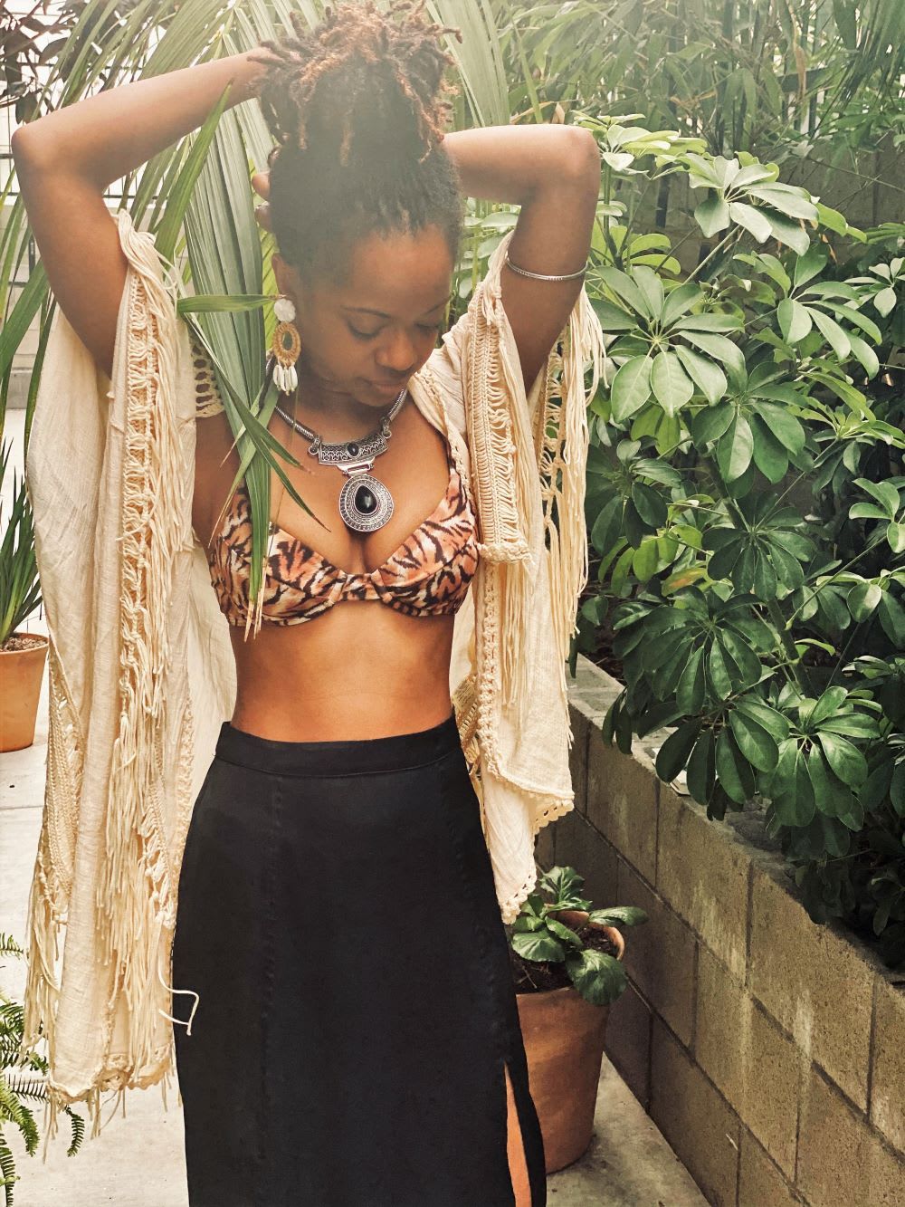 menstrual equity activist chelsea vonchaz of happy period fixes her hair in a bikini top and fringe swim cover up