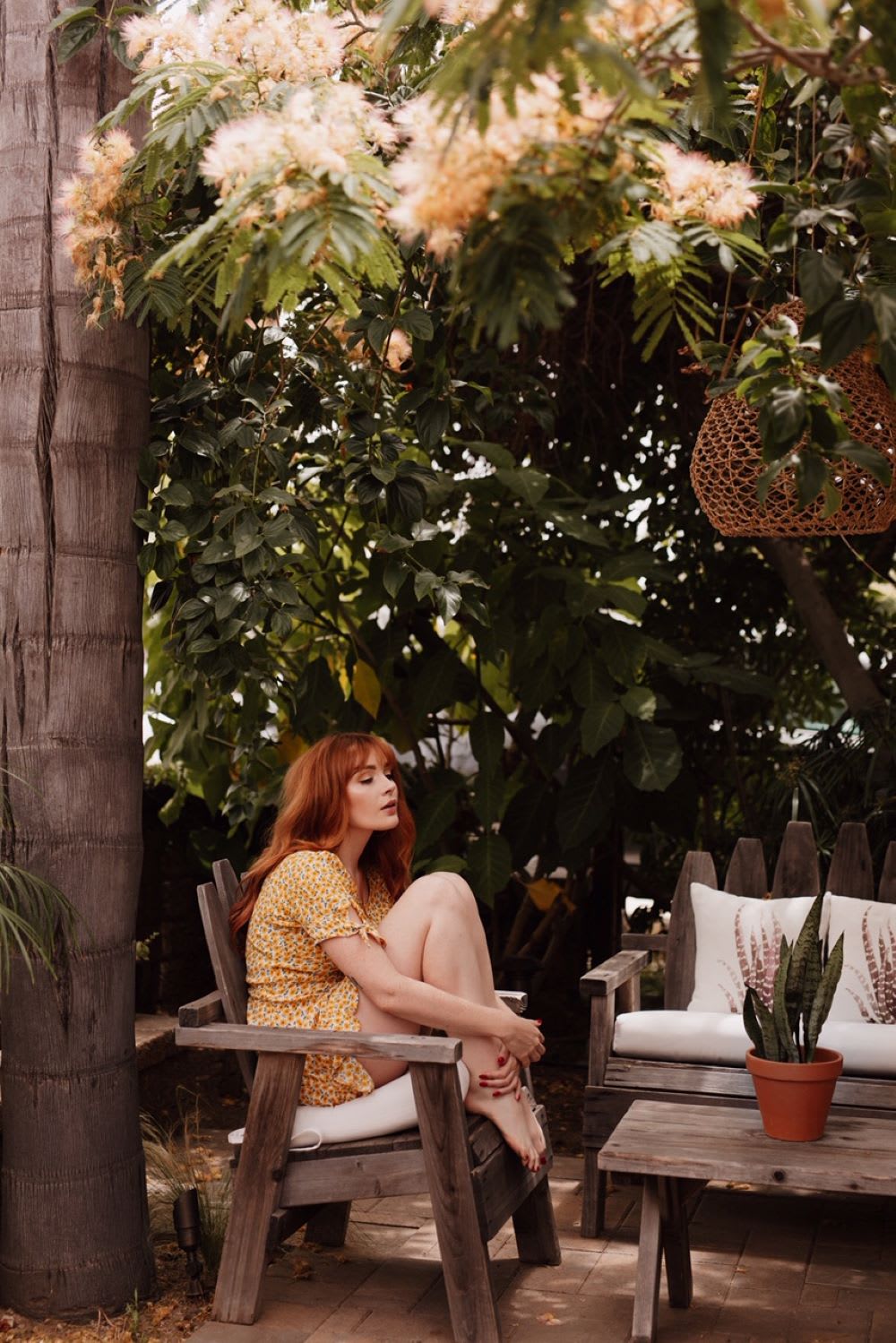 woman sitting outside in social isolation wearing a yellow dress