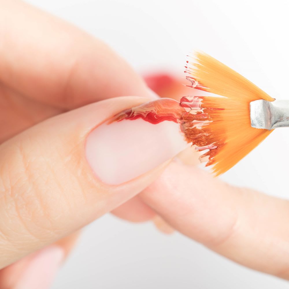 brush applying polish for geode nails design