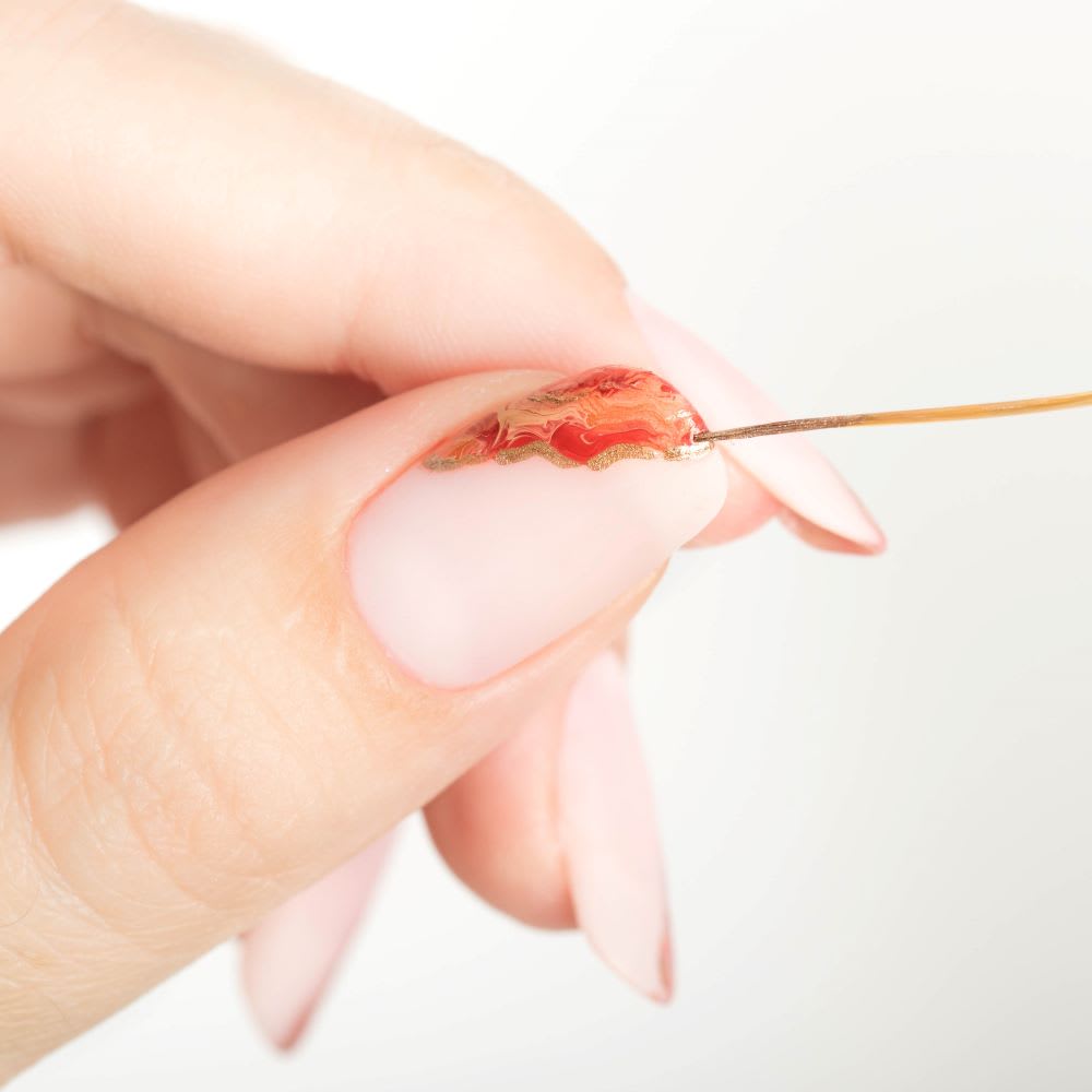 painting gold edges on orange geode nails design