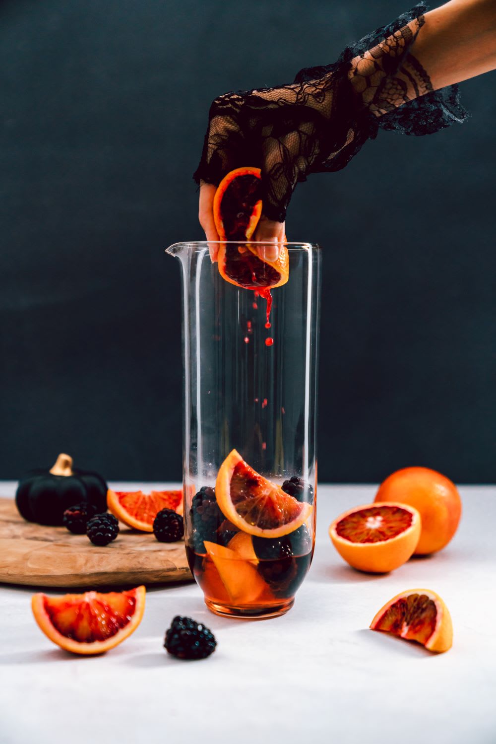 squeezing blood orange into halloween sangria