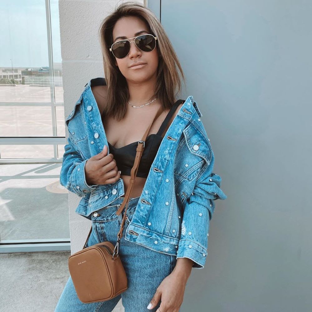 woman in rhinestone denim jacket and bra top