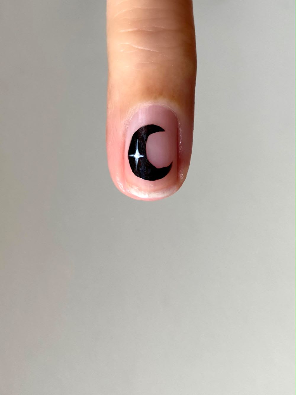 black moon with white detail on nude nail