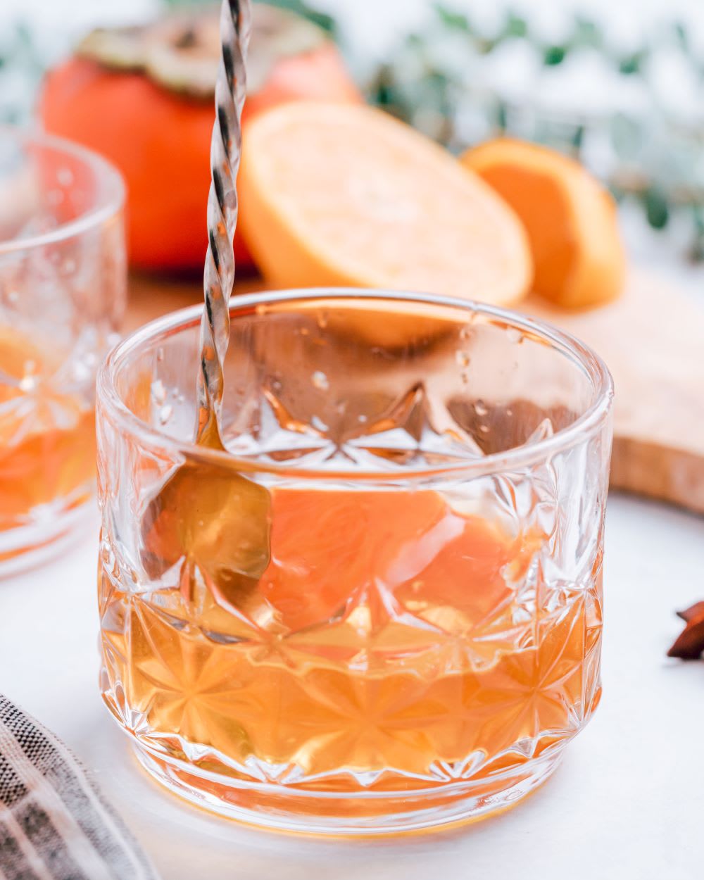 stirring a persimmon old fashioned 