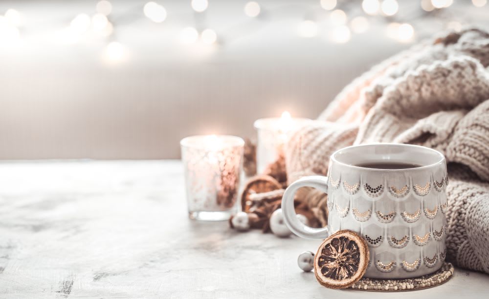 white holiday decor with sweater and candles and lights