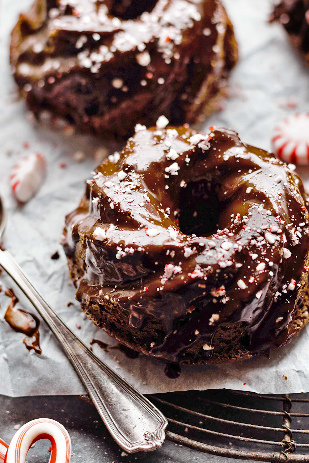 closeup of a mini chocolate bundt cake with crushed candy cane and ganache topping