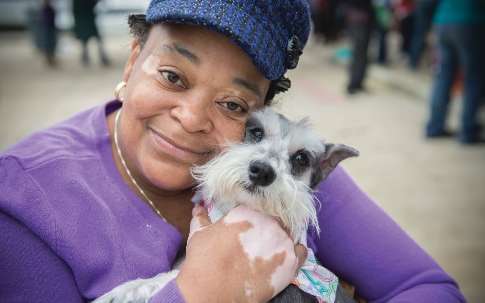 an elderly Black woman holding her dog as an example of diversity and inclusion in pet adoption