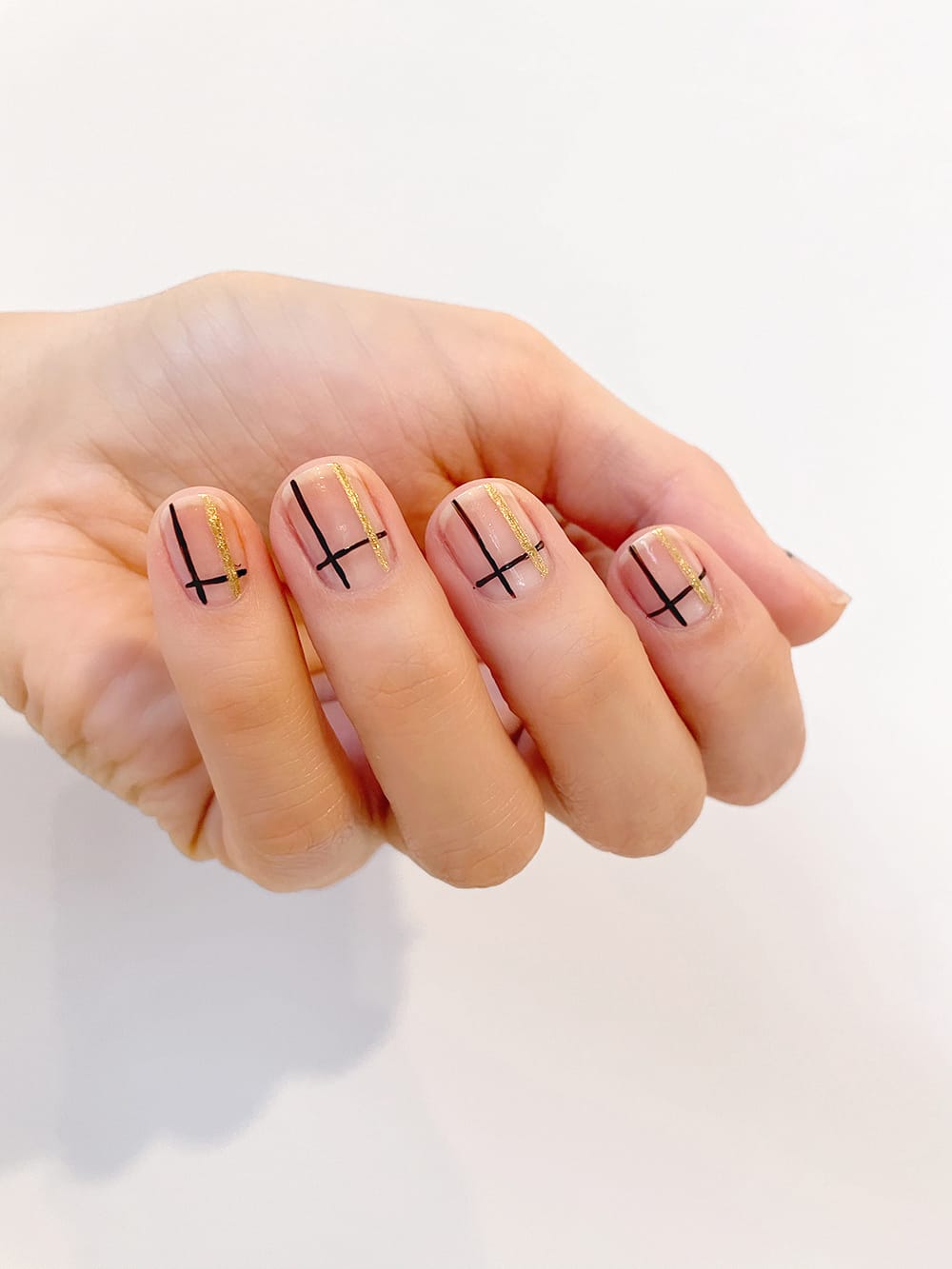 step 5 of nail tutorial adding gold lines to black lines for pattern