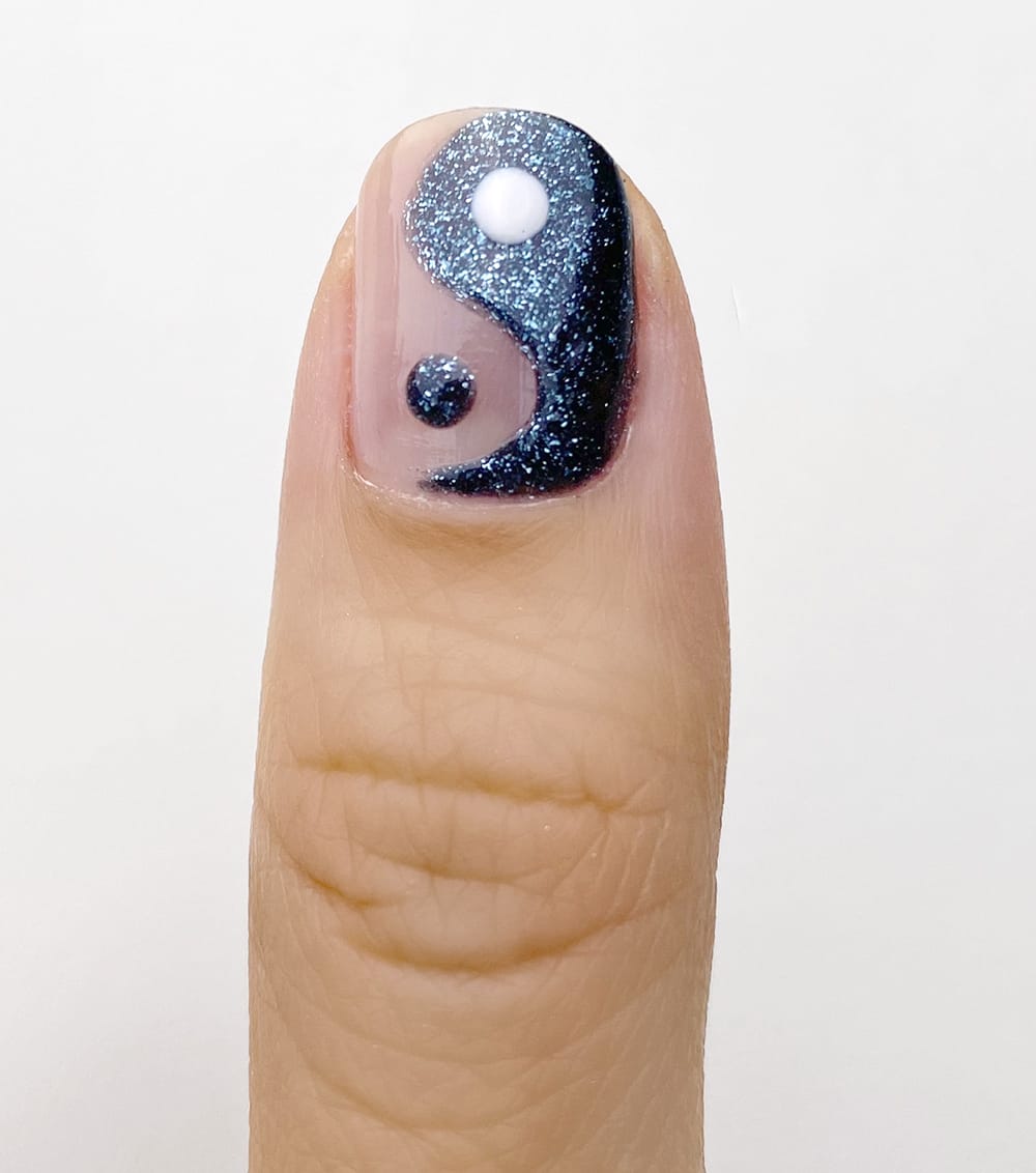 yin yang design with sparkly dark blue nail polish
