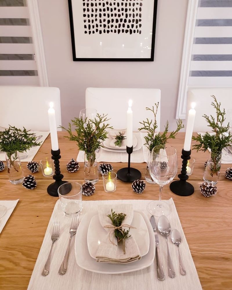 minimalist christmas tabescape with pine cones and cedar greenery