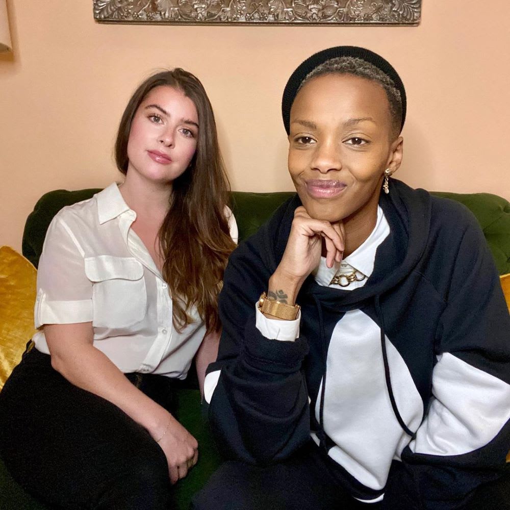 hannah and yseult of the kinswomen podcast sitting on a couch together