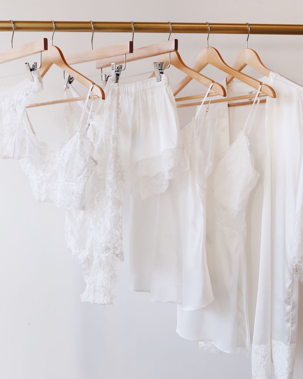 white satin lingerie and sleepwear hanging on a rack