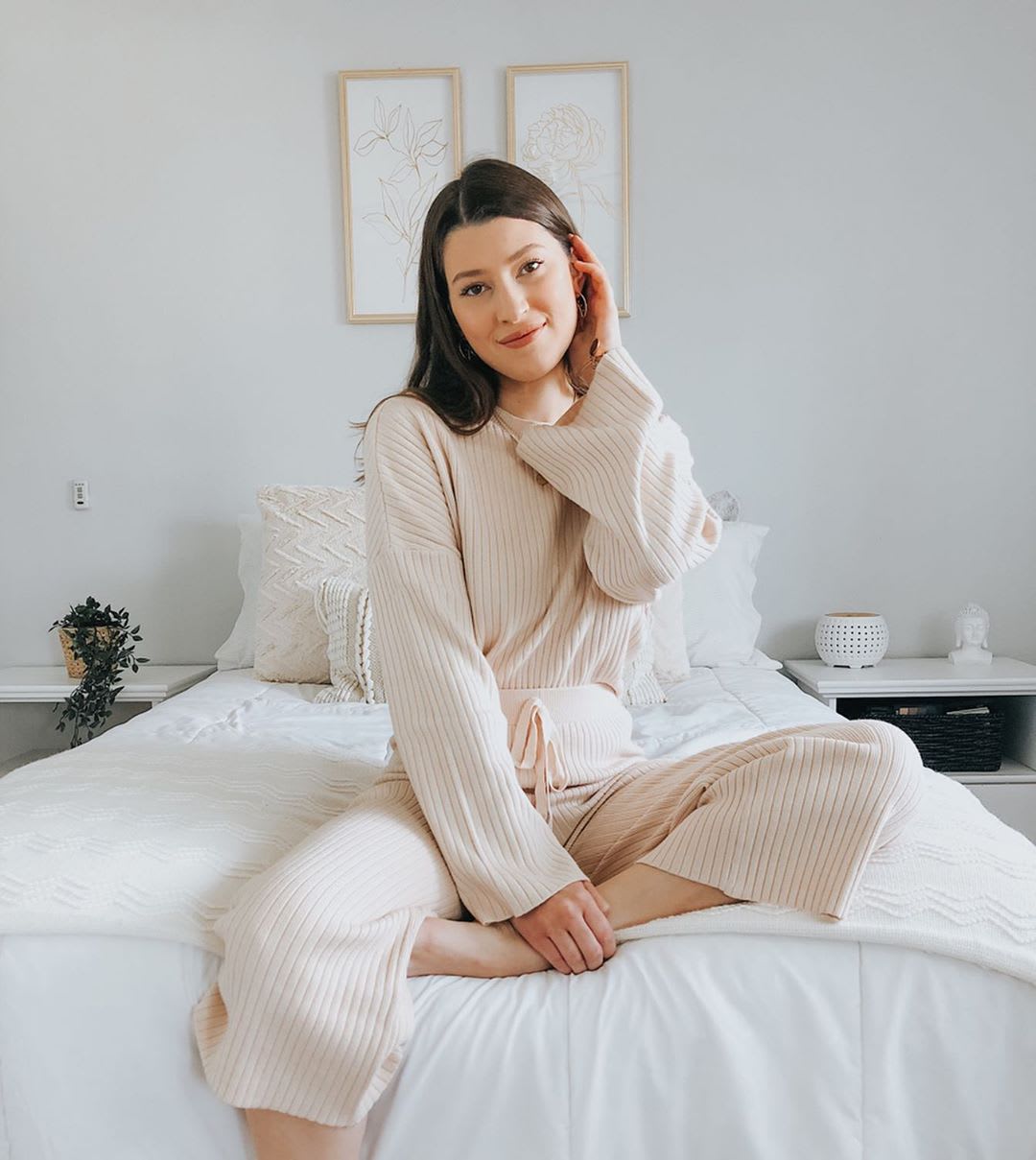 woman sitting on the edge of a bed wearing loungewear set
