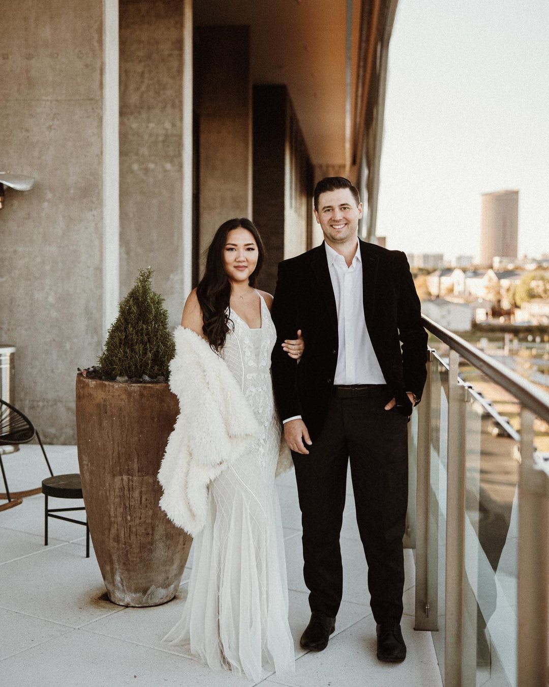 a bride and groom on a rooftop overlooking the city on wedding day