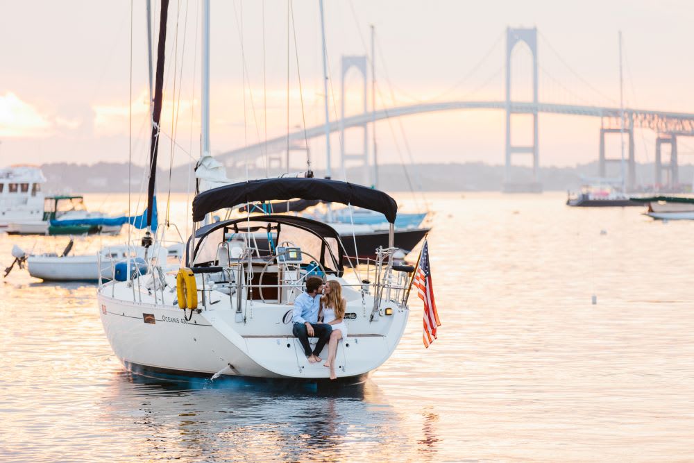 engagement photo of a couple on a boat in the newport harbor in rhode island