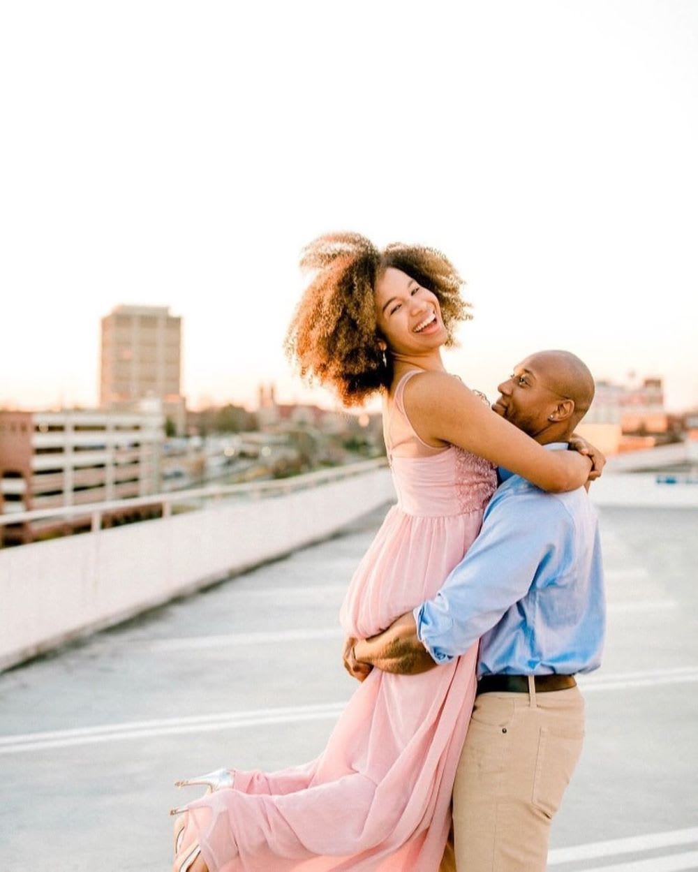 a couple embracing for engagement photos in a parking garage outdoors