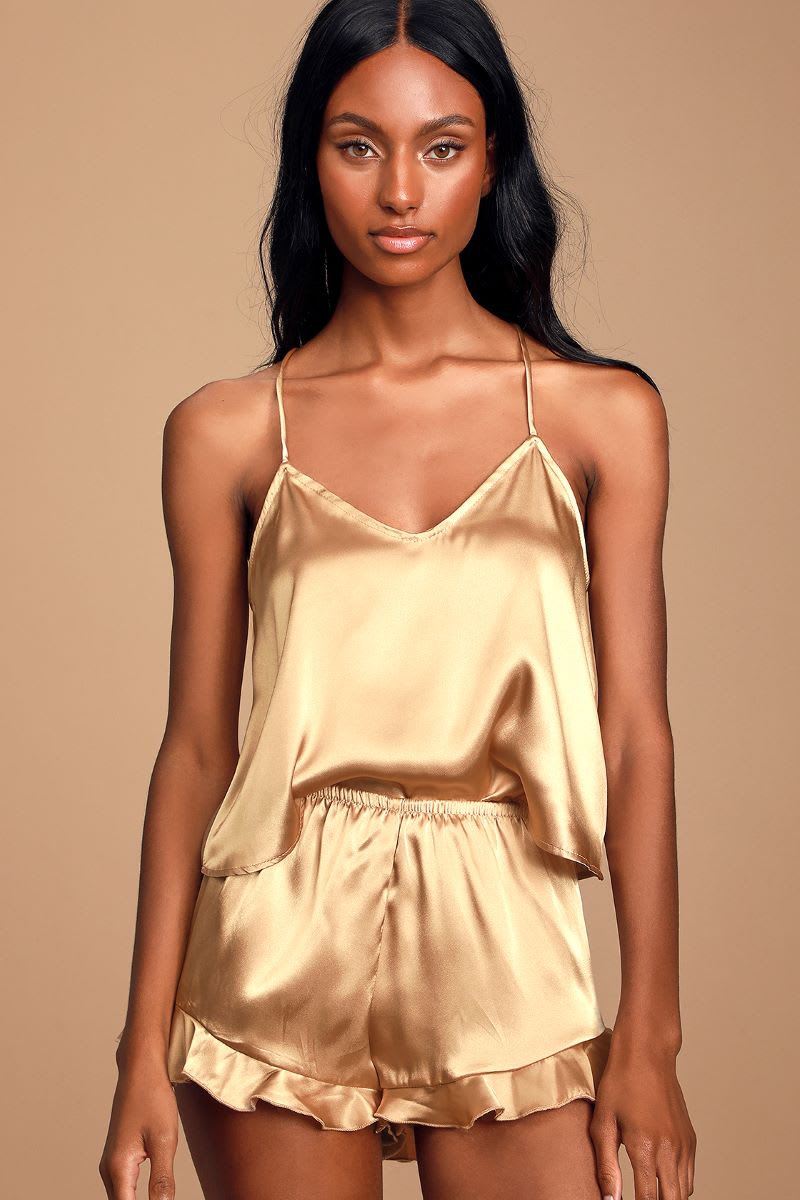 a model wearing a gold satin ruffled two piece pajama set