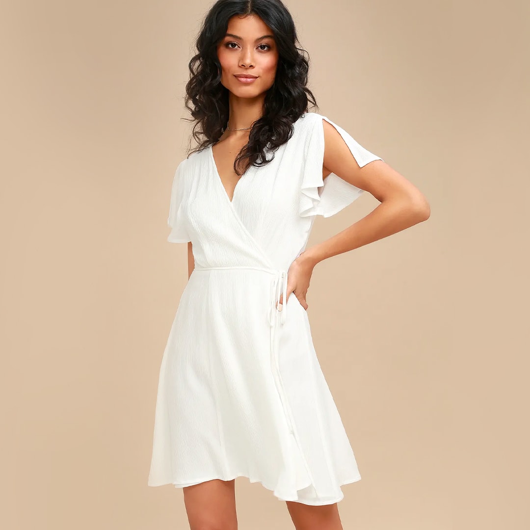 a model wearing a short white wrap dress with split flutter sleeves
