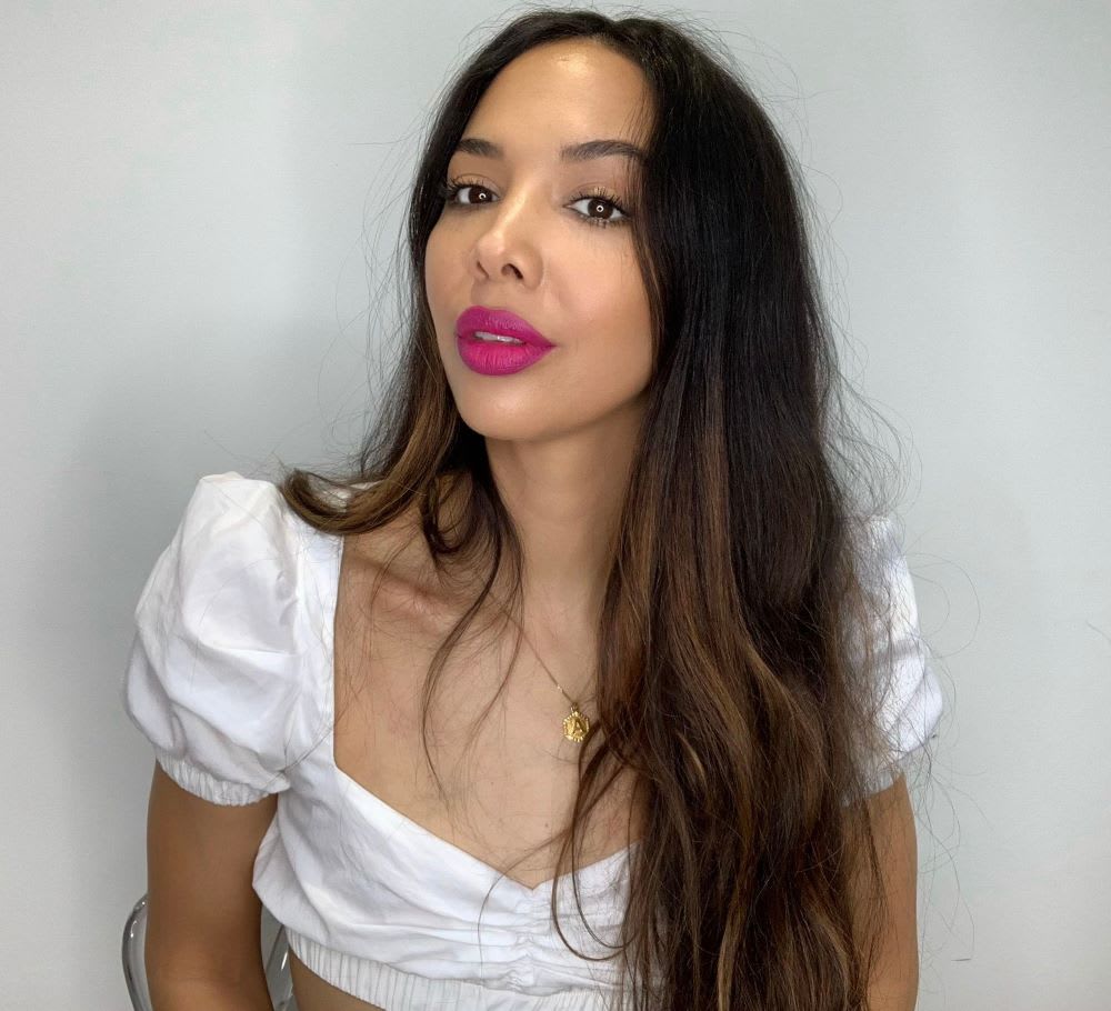 a woman in a white puff sleeve top wearing bold lipstick