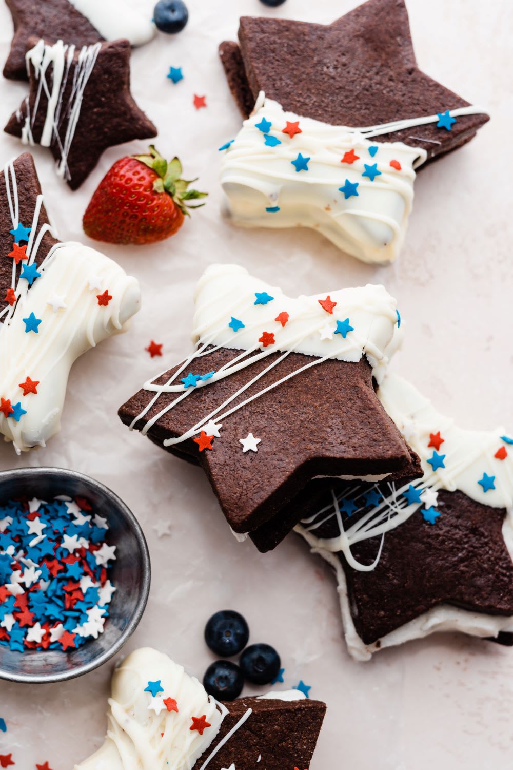 star shaped ice cream sandwiches made with chocolate sugar cookie and red white and blue sprinkles