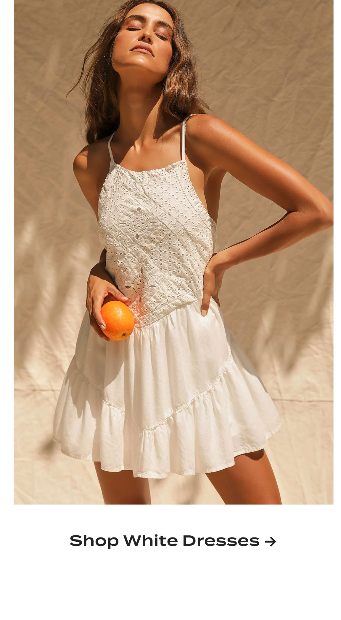 Model wearing white eyelet lace mini dress