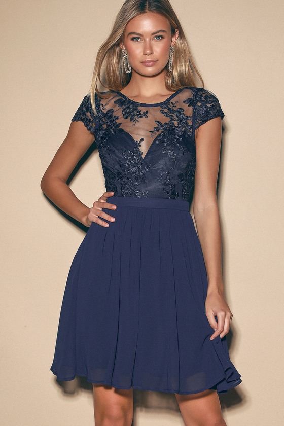 Making Memories Navy Blue Lace Backless Skater Dress - Every moment spent in the Making Memories Navy Blue Lace Backless Skater Dress is one you won't soon forget! Gorgeous embroidered mesh has a lace-like design at it creates a high illusion neckline and short cap sleeves. Wide back keyhole has scalloped edges and a round button closure. Darted, sweetheart bodice sits atop a high, banded waist. Extra twirly skater skirt gets a little added drama with a hidden tulle layer. Hidden back zipper/clasp.