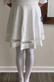 I bought this dress to wear for a Nursing graduation/pinning ceremony as it looked to be pure white from the photo. It definitely has a little yellow tint to it (that you can see when paired with my required white tights for the graduation ceremony). It also runs a little small for me. I normally wear a L or XL in Lulus clothing depending on the fit. I initially ordered a L and it wouldn't zip so I exchanged for an XL. It zipped but it just felt awkward and didn't feel right. Unfortunately they don't offer a bigger size. I am attaching my very unflattering photo so you can see the comparison between the pure white tights and the dress. - Lauren I.
