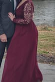 This dress is absolutely beautiful and very comfortable! I got a million compliments in it. I do have a decent sized chest but I still felt covered yet sexy (I wore a sticky bra). My only complaints are that the sleeves have no give .They are very difficult to put on if your arms are of any size (fat or muscular) as the material is delicate. Also the hook and eye on the top is the only thing holding it together so you can imagine my panic when the eye broke in the middle of the wedding reception I was at, thank god the lace I hooked it to held up! Length was perfect with heels! Sorry the picture is puffed out, it was very windy! - Jessica D.