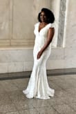I absolutely love this dress. It was perfect for our October courthouse wedding. It has just the right amount of train. It accentuates curves but isn't too tight. The right amount of cleavage that says sexy and classy. It is more ivory/off-white than white. A nice mid to low back that is very elegant. I felt like the most beautiful bride in the world. - Laura R.