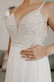 This was the perfect dress for my destination wedding. It did not wrinkle very much during my flight, and the small wrinkles came out easily with a steamer. I did have the front fully lined so you couldn't see the cups in pictures. It photographed and flowed beautifully! I also had better cups sewn in. I could not have been happier with this dress! - Caroline S.