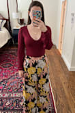 The fit and material are very flattering. It's form fitting while still smoothing over tummy rolls. I usually don't go for puffy sleeves because I feel that they exaggerate my wide shoulders, but the extra fabric in these is more in the arm than the shoulder which gives the illusion of a smaller waist. It's a bit lower-cut than I usually go for, but the fact that is a body suit means you don't have to worry about accidentally showing an errant boob. This is a great staple piece, I'd definitely recommend it. - Annie S.