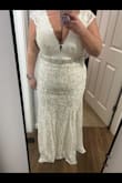 The only thing I would change about this dress is that I wish it was "whiter". It's definitely more of a beige cream color but the lace flower detail at the bust is gorgeous. I also wish it had a bit more length in the back. I'm 5'1 and am wearing 4-inch heels in this picture. I feel like it runs a tad small personally. I added a beaded belt and loved it. I will be wearing this for our small hometown ceremony we're having for my dad. I have a really expensive gown I'm wearing for our big out-of-town wedding. - Shelby W.
