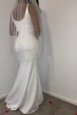This dress was perfect for my home wedding. I purchased three dresses from Lulus and this was my favorite. I am tall for my size but the dress fit perfectly. I am "between" sizes. Sometimes I'm too big for an XS and too small for a Small but this was perfect. To me, it didn't seem pure white, more of a cream or light ivory. I ended up getting an ivory veil to match because I felt the white veil was too white and didn't match but again it was a home wedding and the lights may have played a big part in that. Some guests agreed the dress was cream/ light ivory, some said it was definitely white. The picture of my grandpa and me is the photographer's picture. The other one was taken with an iPhone (the newest version). I definitely believe it's more of an off white/cream/light ivory combo. But it worked perfectly for me. - Damesha B.